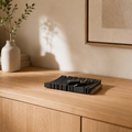 Vionel Nest groß in Schwarz-Braun mit Alltagsgegenständen auf einem hellen Holz-Sideboard.
