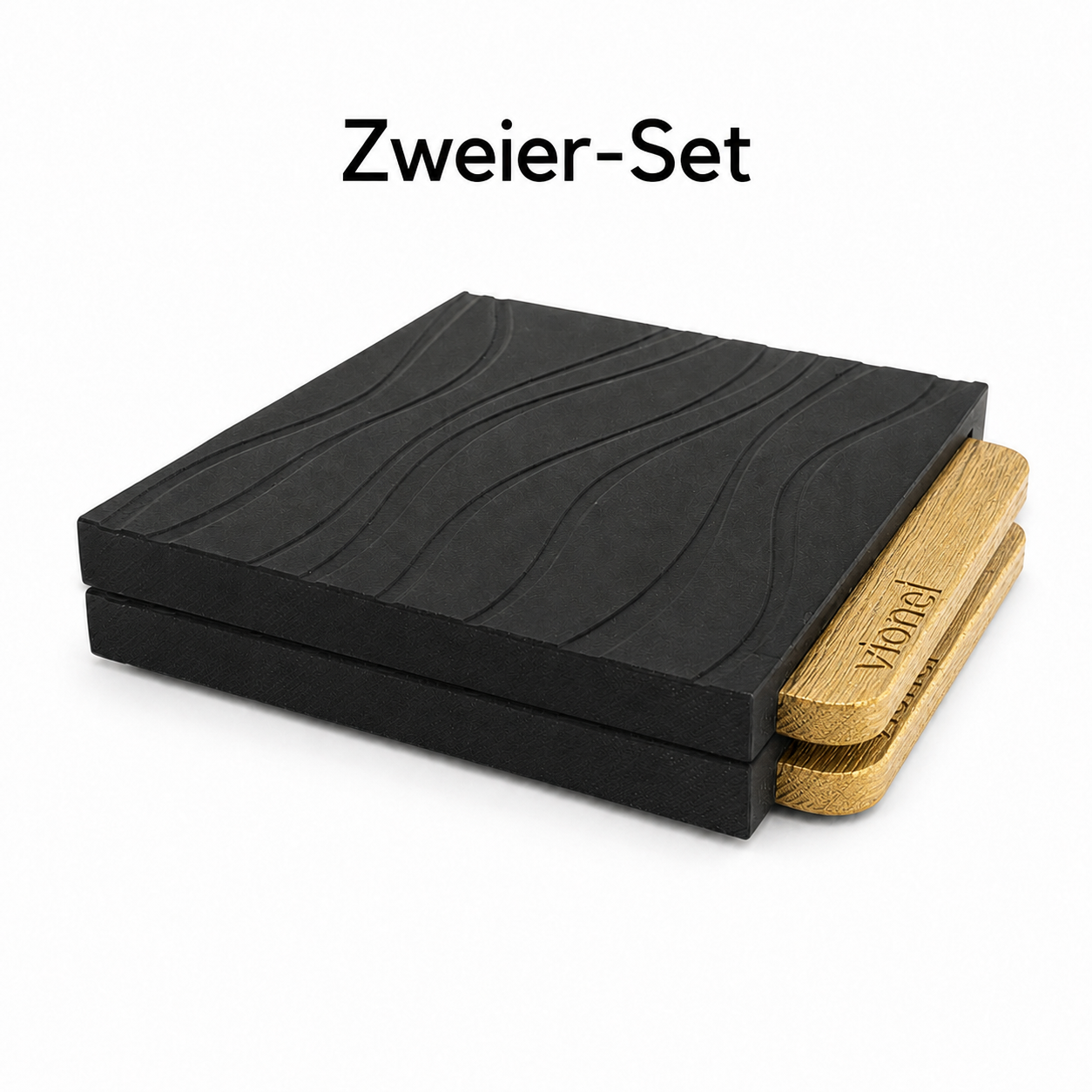 Zwei schwarze Vionel Nami Tassenuntersetzer mit Wellenstruktur und goldenen PLA-Wood-Detail auf weißem Hintergrund.